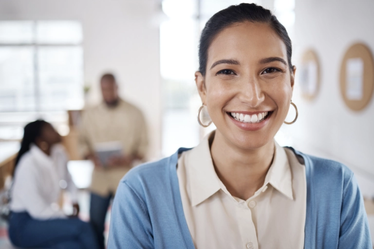 snap satisfaction client Femme souriante bureau moderne, coworkers en arrière-plan.